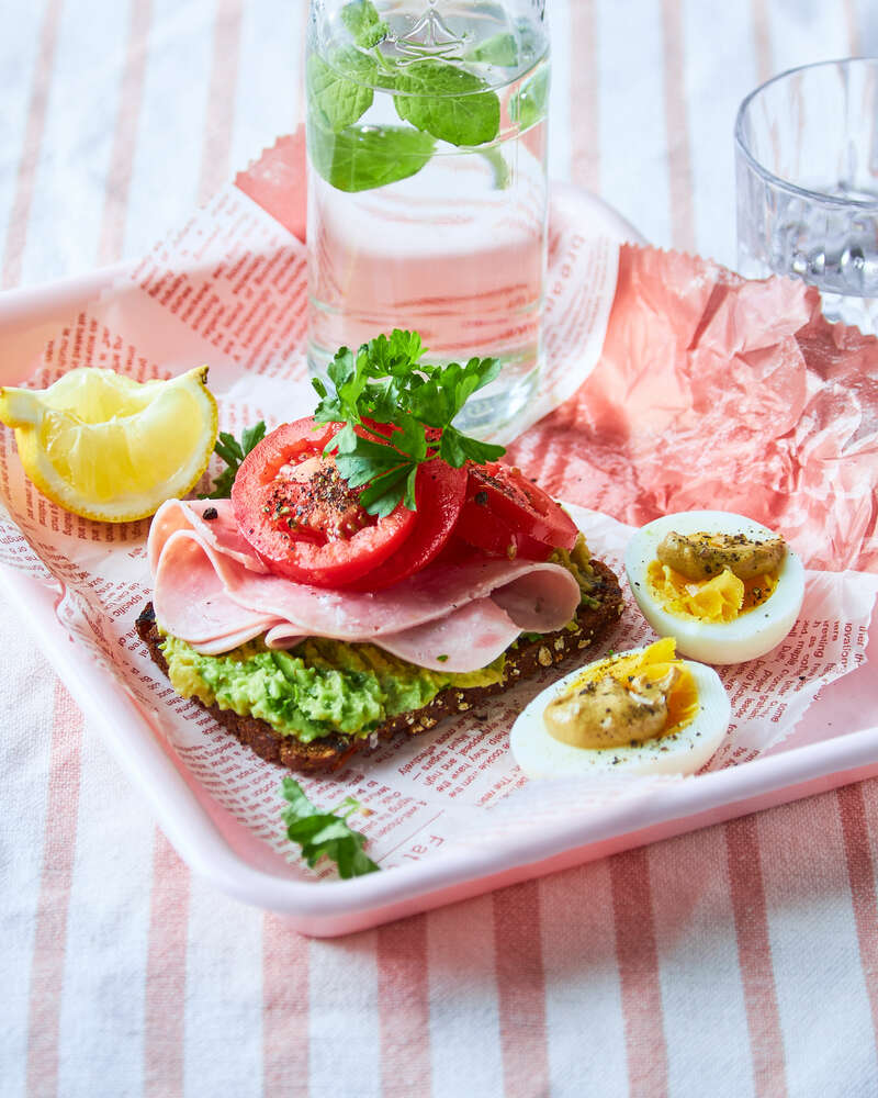 Ristet rugbrød med avokado, skinke og tomat dertil æg med sennep ...