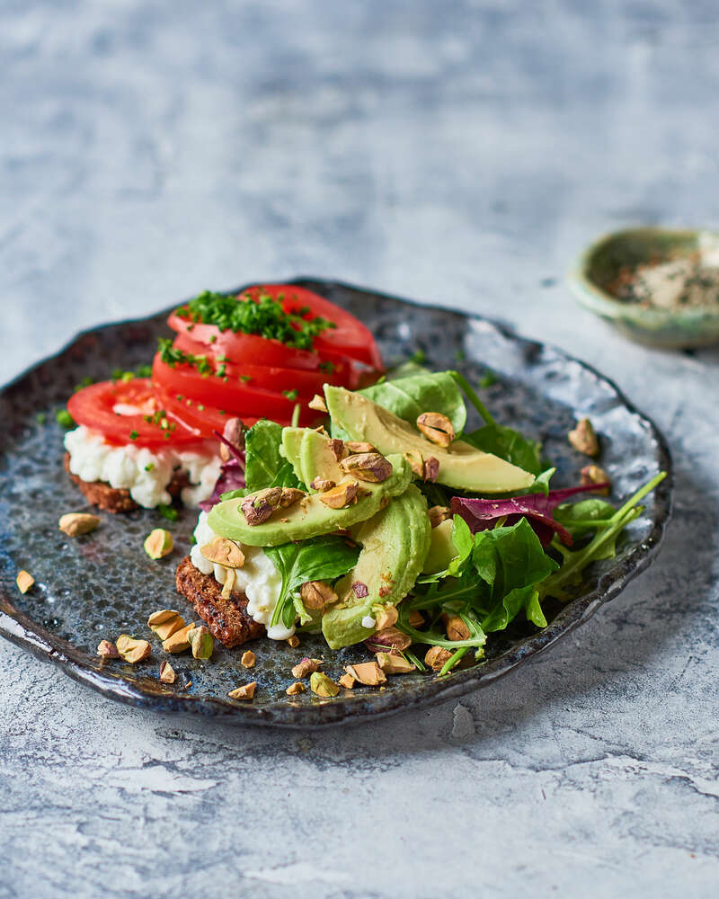 Rugbrød med hytteost, tomat og avokado toppet med pistacienødder ...
