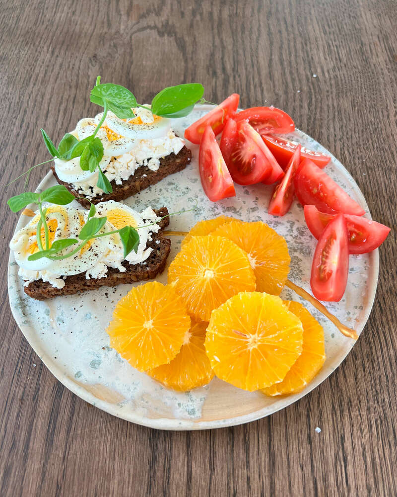 Rugbrød med ost og æg dertil tomat og appelsin - Sense opskrift